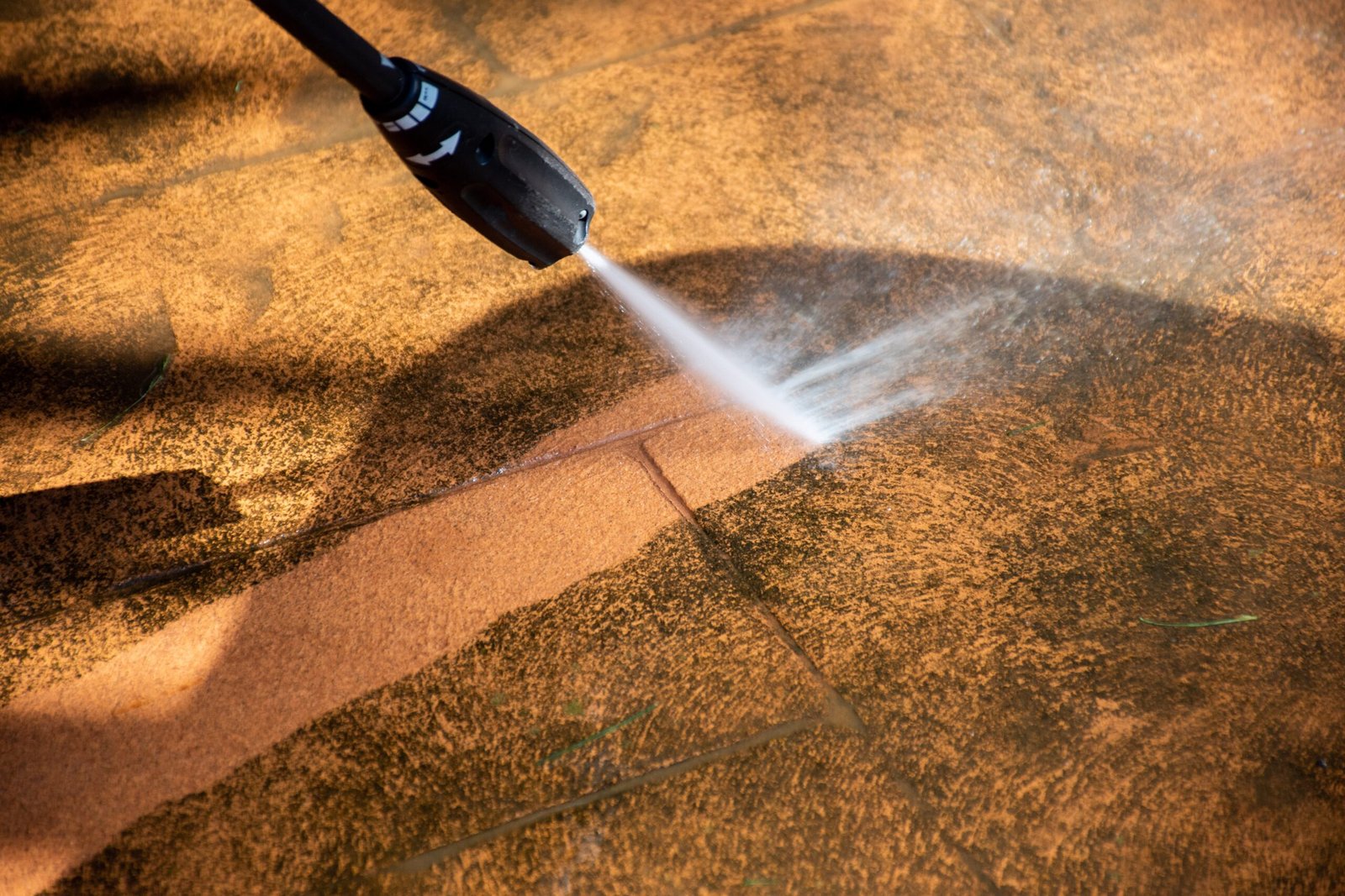 Outdoor patio tile surface being pressure washed